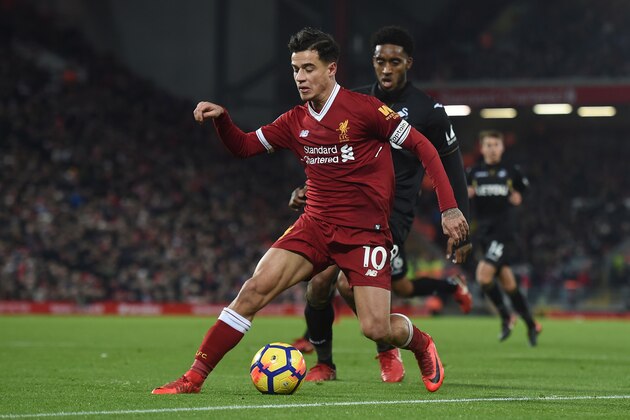 Liverpool's Brazilian midfielder Philippe Coutinho (L) takes on Swansea City's Dutch midfielder Leroy Fer (R) during the English Premier League football match between Liverpool and Swansea City at Anfield in Liverpool, north west England on December 26, 2017. / AFP PHOTO / PAUL ELLIS / RESTRICTED TO EDITORIAL USE. No use with unauthorized audio, video, data, fixture lists, club/league logos or 'live' services. Online in-match use limited to 75 images, no video emulation. No use in betting, games or single club/league/player publications.  /         (Photo credit should read PAUL ELLIS/AFP/Getty Images)