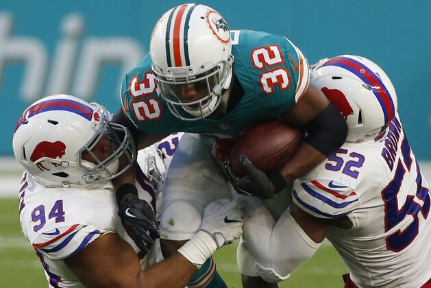 Buffalo Bills middle linebacker Preston Brown (52) and nose tackle Rickey Hatley (94), attempt to stop Miami Dolphins running back Kenyan Drake (32), during the first half of an NFL football game, Sunday, Dec. 31, 2017, in Miami Gardens, Fla. (AP Photo/Wilfredo Lee)