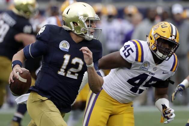Notre Dame quarterback Ian Book (12) shambles for yardage past LSU linebacker Michael Divinity Jr. (45) during the first half of the Citrus Bowl NCAA college football game, Monday, Jan. 1, 2018, in Orlando, Fla. (AP Photo/John Raoux)