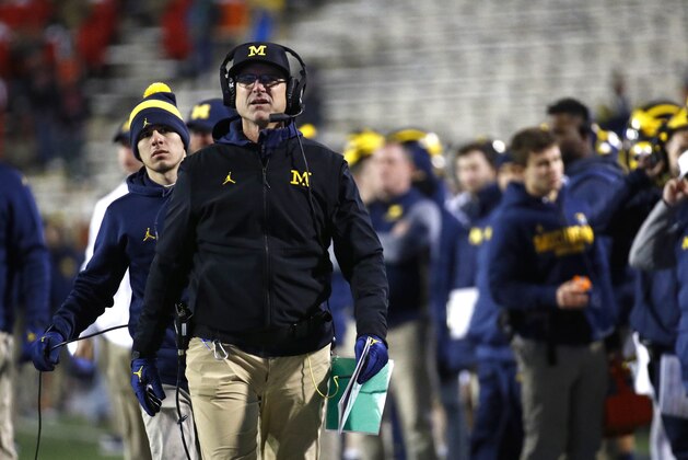 FILE - In this Saturday, Nov. 11, 2017, file photo, Michigan head coach Jim Harbaugh walks on the sideline in the second half of an NCAA college football game against Maryland in College Park, Md. Don't try to sell Harbaugh or Will Muschamp on the notion that New Year's Day games that are not part of the College Football Playoff are irrelevant. The coaches for Michigan and South Carolina expect to contend for national championships moving forward, but also feel it's important to finish this season with a strong performance in the Outback Bowl. (AP Photo/Patrick Semansky, File)