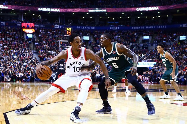 TORONTO, ON - JANUARY 01:  DeMar DeRozan #10 of the Toronto Raptors dribbles the ball as Eric Bledsoe #6 of the Milwaukee Bucks defends during the second half of an NBA game at Air Canada Centre on January 1, 2018 in Toronto, Canada.  NOTE TO USER: User expressly acknowledges and agrees that, by downloading and or using this photograph, User is consenting to the terms and conditions of the Getty Images License Agreement.  (Photo by Vaughn Ridley/Getty Images)