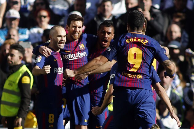 TOPSHOT - Barcelona's Argentinian forward Lionel Messi (2L) celebrates with Barcelona's Spanish midfielder Andres Iniesta, Barcelona's Brazilian midfielder Paulinho and Barcelona's Uruguayan forward Luis Suarez after scoring during the Spanish League 'Clasico' football match Real Madrid CF vs FC Barcelona at the Santiago Bernabeu stadium in Madrid on December 23, 2017.  / AFP PHOTO / OSCAR DEL POZO        (Photo credit should read OSCAR DEL POZO/AFP/Getty Images)