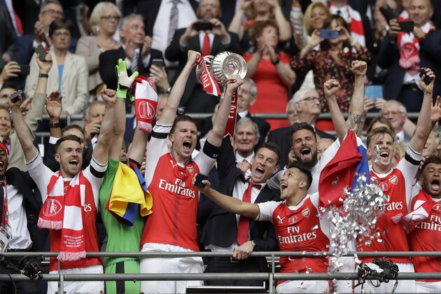 Arsenal's players celebrate with the trophy after winning the English FA Cup final soccer match between Arsenal and Chelsea at the Wembley stadium in London, Saturday, May 27, 2017. (AP Photo/Matt Dunham)