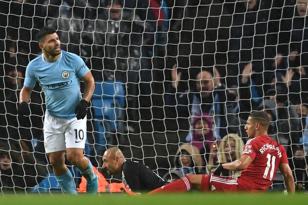 Manchester City's Argentinian striker Sergio Aguero scores their third goal past Watford's Brazilian goalkeeper Heurelho Gomes (2R) during the English Premier League football match between Manchester City and Watford at the Etihad Stadium in Manchester, north west England, on January 2, 2018. / AFP PHOTO / Paul ELLIS / RESTRICTED TO EDITORIAL USE. No use with unauthorized audio, video, data, fixture lists, club/league logos or 'live' services. Online in-match use limited to 75 images, no video emulation. No use in betting, games or single club/league/player publications.  /         (Photo credit should read PAUL ELLIS/AFP/Getty Images)