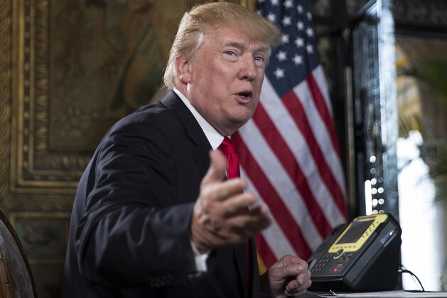 President Donald Trump turns to talk to the gathered media during a Christmas Eve video teleconference with members of the mIlitary at his Mar-a-Lago estate in Palm Beach, Fla., Sunday, Dec. 24, 2017. (AP Photo/Carolyn Kaster)
