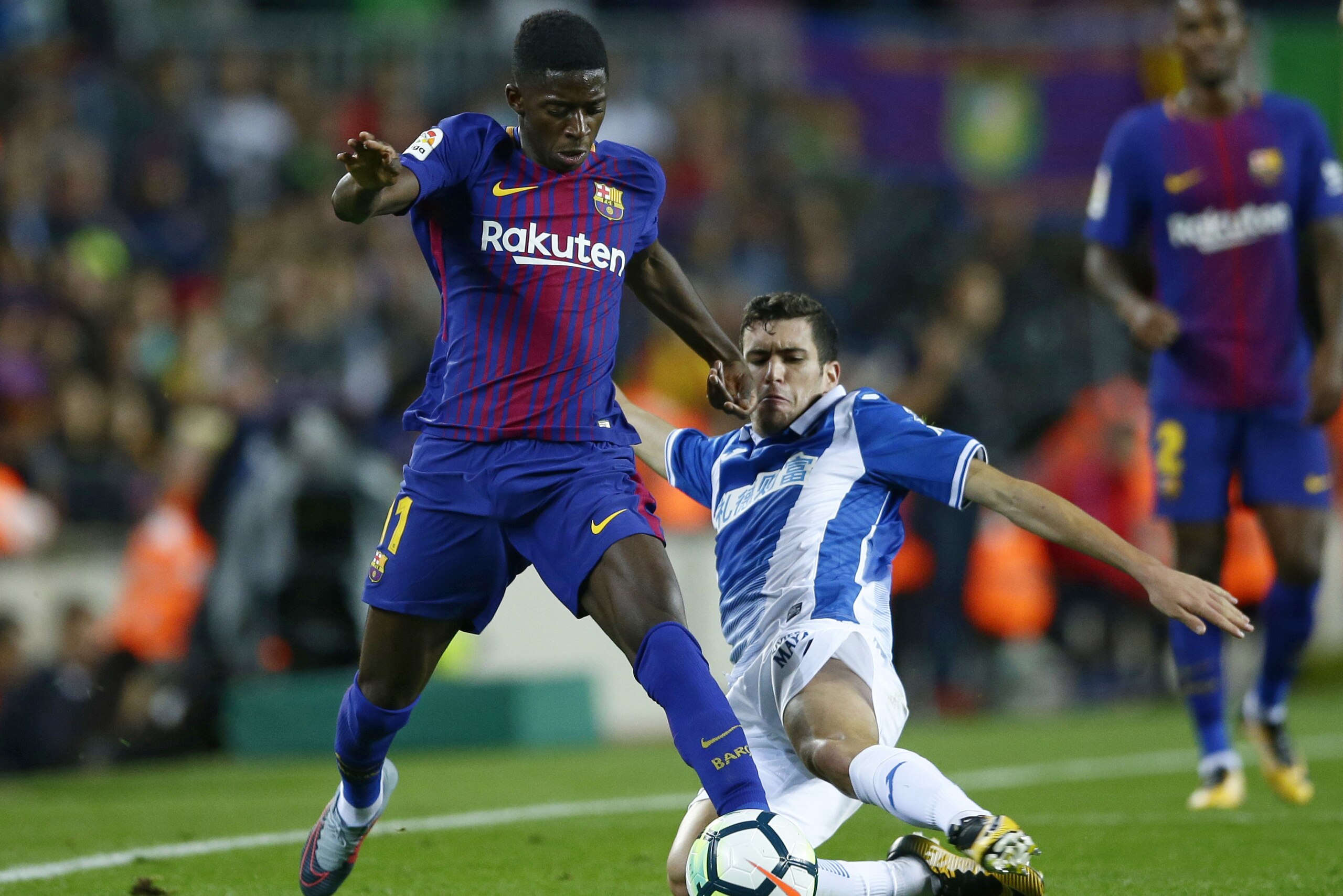 FC Barcelona's Ousmane Dembele, left, duels for the ball against Espanyol's Aaron Martin during the Spanish La Liga soccer match between FC Barcelona and Espanyol at the Camp Nou stadium in Barcelona, Spain, Saturday, Sept. 9, 2017. (AP Photo/Manu Fernandez)