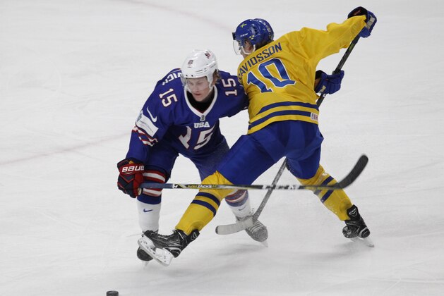 United States defenseman Scott Perunovich (15) attempts to skate past Sweden forward Marcus Davidsson (10) during the third period of a semifinal in the IIHF world junior hockey championships, Thursday, Jan. 4, 2018, in Buffalo, N.Y. (AP Photo/Jeffrey T. Barnes)