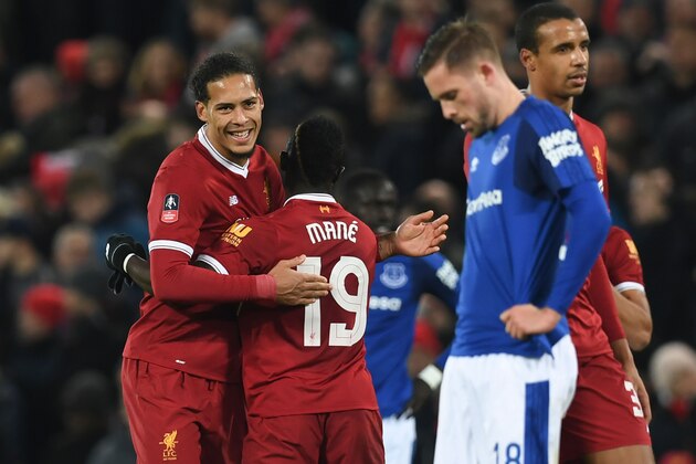 Liverpool's Dutch defender Virgil van Dijk (L) hugs Liverpool's Senegalese midfielder Sadio Mane (2L) at the end of the English FA Cup third round football match between Liverpool and Everton at Anfield in Liverpool, north west England on January 5, 2018. / AFP PHOTO / Paul ELLIS / RESTRICTED TO EDITORIAL USE. No use with unauthorized audio, video, data, fixture lists, club/league logos or 'live' services. Online in-match use limited to 75 images, no video emulation. No use in betting, games or single club/league/player publications.  /         (Photo credit should read PAUL ELLIS/AFP/Getty Images)