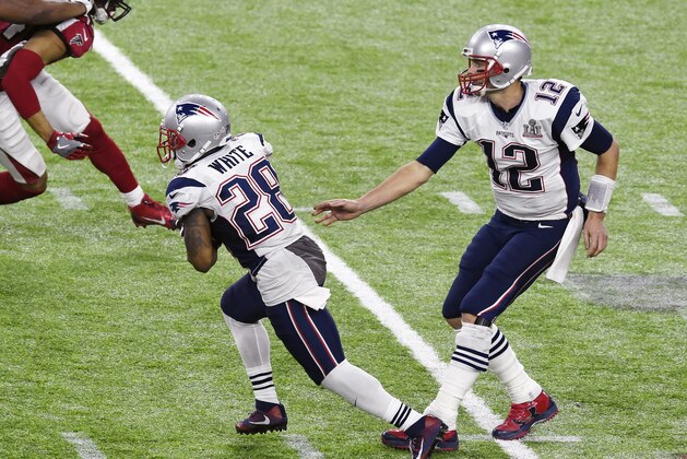 HOUSTON, TX - FEBRUARY 05: James White #28 of the New England Patriots takes the handoff from Tom Brady #12 against the Atlanta Falcons during Super Bowl 51 at NRG Stadium on February 5, 2017 in Houston, Texas. The Patriots defeat the Atlanta Falcons 34-28 in overtime. (Photo by Focus on Sport/Getty Images)