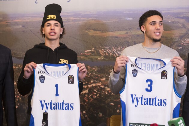 American basketball players LiAngelo Ball, right, and his brother, LaMelo, show their shirts after signing for Lithuanian team BC Prienai - Birstonas Vytautas, during a news conference at the Harmony park hotel in Vaizgaikiemis village, Prienai district, Lithuania, Friday, Jan. 5, 2018. LiAngelo Ball and LaMelo Ball signed a one-year contracts to play for Lithuanian professional basketball club Prienai - Birstonas Vytautas in the southern Lithuania town of Prienai, some 110 km (68 miles) from the Lithuanian capital Vilnius.(AP Photo/Mindaugas Kulbis)