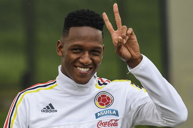 Colombia's defender Yerry Mina makes the 'v' sign to the journalists before a training session at the Colombian football Federation in Bogota on March 25 2017 ahead of their FIFA World Cup South American qualifier football match against Ecuador. / AFP PHOTO / Luis Acosta        (Photo credit should read LUIS ACOSTA/AFP/Getty Images)