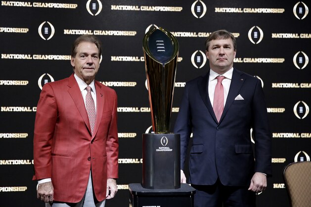 Alabama head coach Nick Saban, left, and Georgia head coach Kirby Smart pose with the NCAA college football championship trophy at a press conference in Atlanta, Sunday, Jan. 7, 2018. Georgia and Alabama will be playing for the championship on Monday, Jan. 8. (AP Photo/David Goldman)