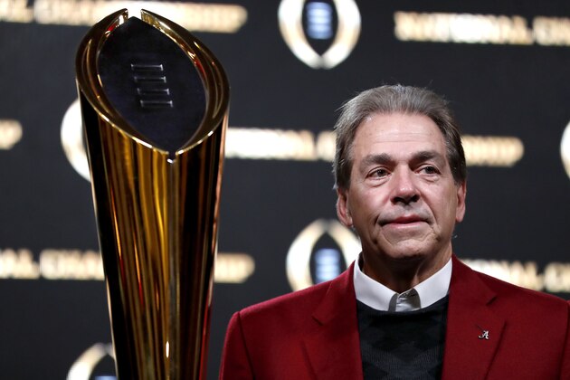 Alabama head coach Nick Saban poses next to the NCAA college football championship trophy at a press conference in Atlanta, Tuesday, Jan. 9, 2018. Alabama beat Georgia 26-23 in overtime to win the NCAA college football playoff championship game on Monday night. (AP Photo/David Goldman)