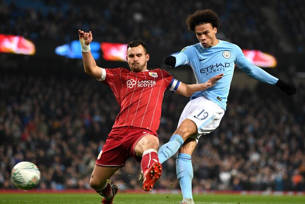 MANCHESTER, ENGLAND - JANUARY 09:  Leroy Sane of Manchester City shoots under pressure from Bailey Wright of Bristol City during the Carabao Cup Semi-Final First Leg match between Manchester City and Bristol City at Etihad Stadium on January 9, 2018 in Manchester, England.  (Photo by Gareth Copley/Getty Images)