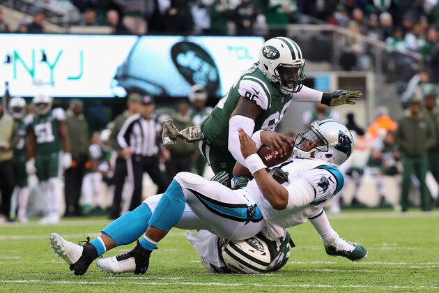 EAST RUTHERFORD, NJ - NOVEMBER 26:  Defensive end Muhammad Wilkerson #96 and inside linebacker Demario Davis #56 of the New York Jets tackle quarterback Cam Newton #1 of the Carolina Panthers during the third quarter of the game at MetLife Stadium on November 26, 2017 in East Rutherford, New Jersey. Carolina Panthers won 35-27.  (Photo by Abbie Parr/Getty Images)