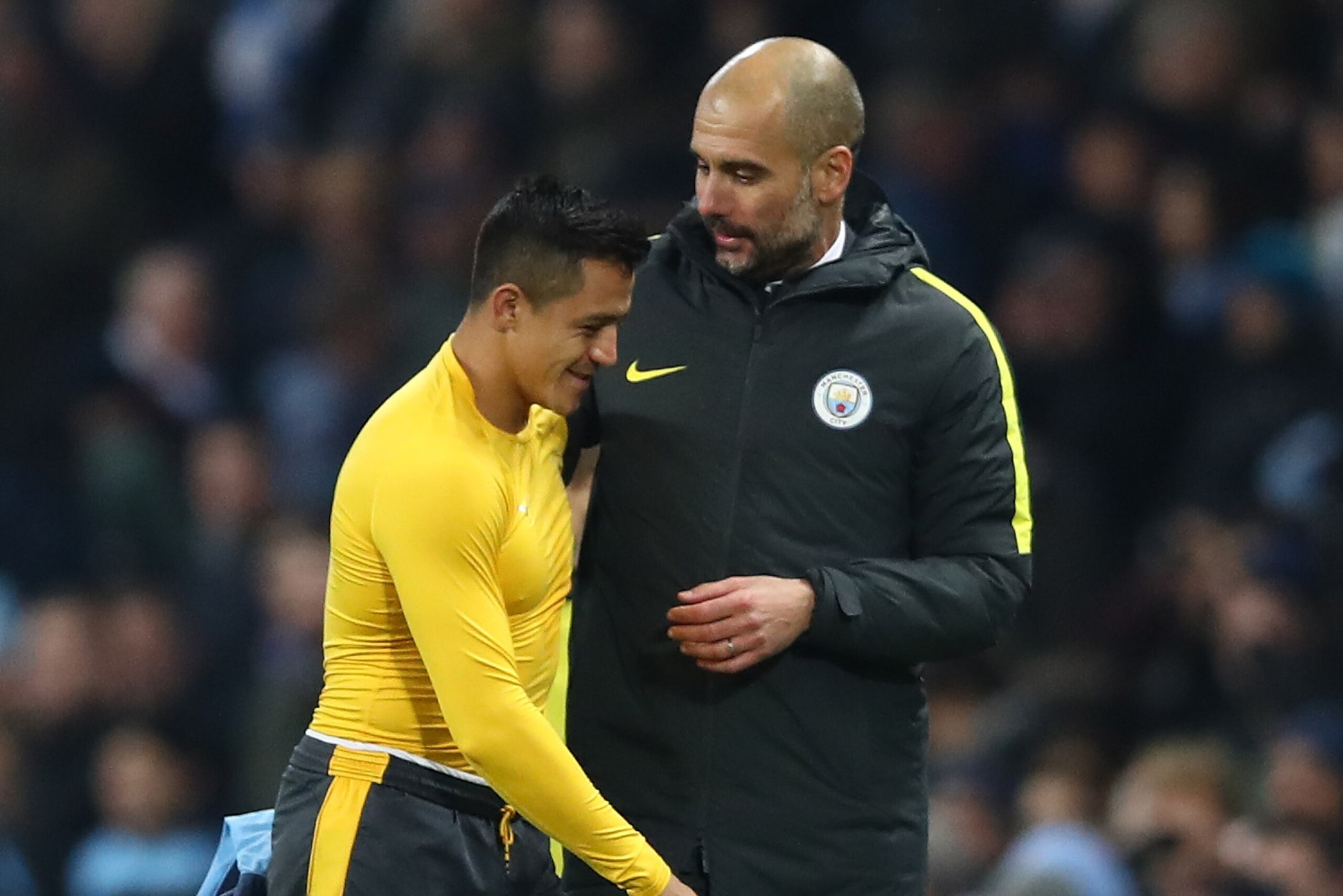MANCHESTER, ENGLAND - DECEMBER 18:  Alexis Sanchez of Arsenal (L) and Josep Guardiola, Manager of Manchester City (R) embrace after the final whistle during the Premier League match between Manchester City and Arsenal at the Etihad Stadium on December 18, 2016 in Manchester, England.  (Photo by Clive Brunskill/Getty Images)