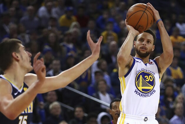 Golden State Warriors' Stephen Curry, right, shoots against Denver Nuggets' Nikola Jokic (15) during the second half of an NBA basketball game Monday, Jan. 8, 2018, in Oakland, Calif. Golden State won, 124-114. (AP Photo/Ben Margot)