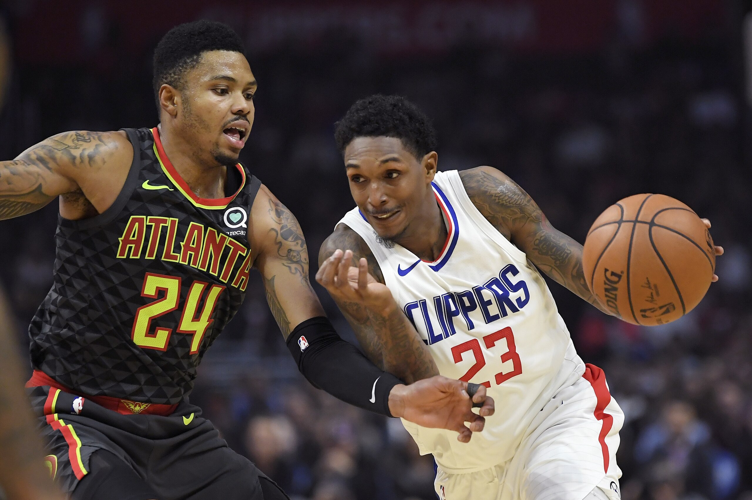 Los Angeles Clippers guard Lou Williams, right, drives by Atlanta Hawks guard Kent Bazemore during the second half of a basketball game, Monday, Jan. 8, 2018, in Los Angeles. The Clippers won 108-107. (AP Photo/Mark J. Terrill)