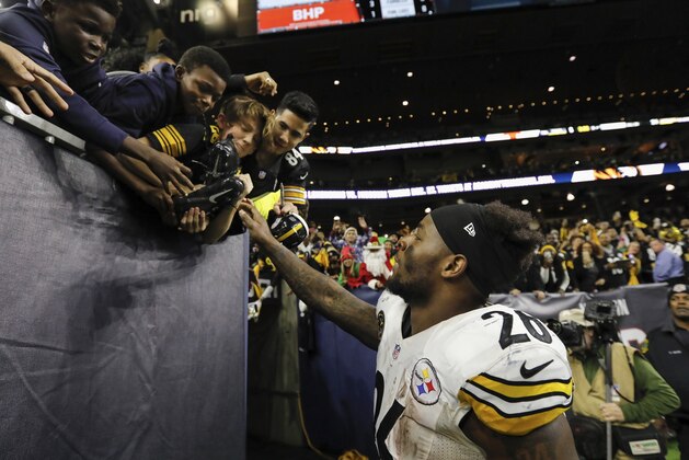 HOUSTON, TX - DECEMBER 25: Le'Veon Bell #26 of the Pittsburgh Steelers gives his cleats to young fans after the game against the Houston Texans at NRG Stadium on December 25, 2017 in Houston, Texas. (Photo by Tim Warner/Getty Images)