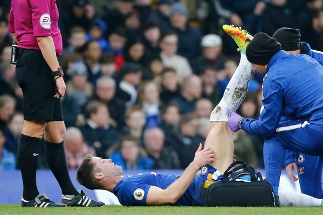 Chelsea's English defender Gary Cahill (C) gets attention before going off injured during the English Premier League football match between Chelsea and Leicester City at Stamford Bridge in London on January 13, 2018. / AFP PHOTO / Tolga AKMEN / RESTRICTED TO EDITORIAL USE. No use with unauthorized audio, video, data, fixture lists, club/league logos or 'live' services. Online in-match use limited to 75 images, no video emulation. No use in betting, games or single club/league/player publications.  /         (Photo credit should read TOLGA AKMEN/AFP/Getty Images)