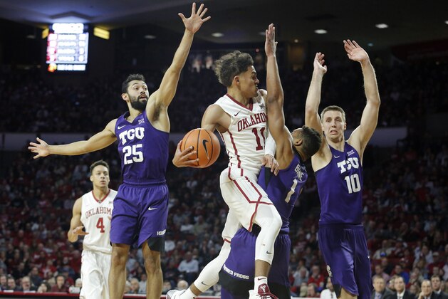 Oklahoma's Trae Young (11) goes up against TCU's Desmond Bane (1), Alex Robinson (25) and Vladimir Brodziansky (10) during the second half of an NCAA college basketball game in Norman, Okla., Saturday, Jan. 13, 2018. (AP Photo/Garett Fisbeck)