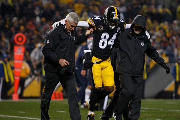 PITTSBURGH, PA - DECEMBER 17: Antonio Brown #84 of the Pittsburgh Steelers is walked off the field by trainers after landing awkwardly while attempting to catch a pass in the second quarter during the game against the New England Patriots at Heinz Field on December 17, 2017 in Pittsburgh, Pennsylvania. (Photo by Justin K. Aller/Getty Images)