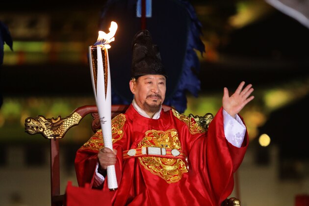 SEOUL, SOUTH KOREA - JANUARY 13:  A torchbearer wearing a traditional King's costume carries the Olympic torch in front of the main entrance to Gyeongbokgung Palace during the PyeongChang 2018 Winter Olympic Games torch relay on January 13, 2018 in Seoul, South Korea.  (Photo by Chung Sung-Jun/Getty Images)