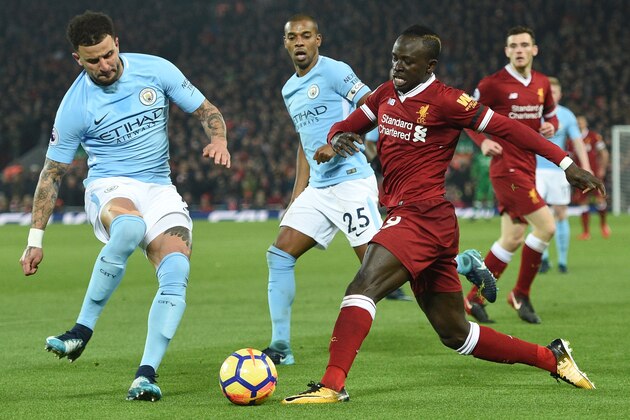 Liverpool's Senegalese midfielder Sadio Mane (R) takes on Manchester City's English defender Kyle Walker (L) and Manchester City's Brazilian midfielder Fernandinho (C) during the English Premier League football match between Liverpool and Manchester City at Anfield in Liverpool, north west England on January 14, 2018. / AFP PHOTO / Oli SCARFF / RESTRICTED TO EDITORIAL USE. No use with unauthorized audio, video, data, fixture lists, club/league logos or 'live' services. Online in-match use limited to 75 images, no video emulation. No use in betting, games or single club/league/player publications.  /         (Photo credit should read OLI SCARFF/AFP/Getty Images)