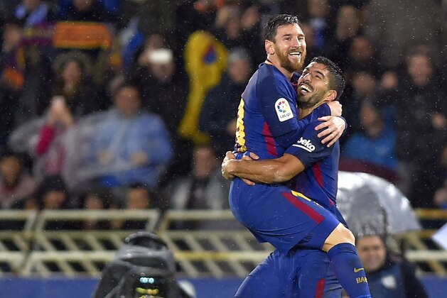 Barcelona's Argentinian forward Lionel Messi (L) is congratulated by teammate Uruguayan forward Luis Suarez after scoring their team's fourth goal during the Spanish league football match between Real Sociedad  and FC Barcelona at the Anoeta stadium in San Sebastian on January 14, 2018. / AFP PHOTO / ANDER GILLENEA        (Photo credit should read ANDER GILLENEA/AFP/Getty Images)
