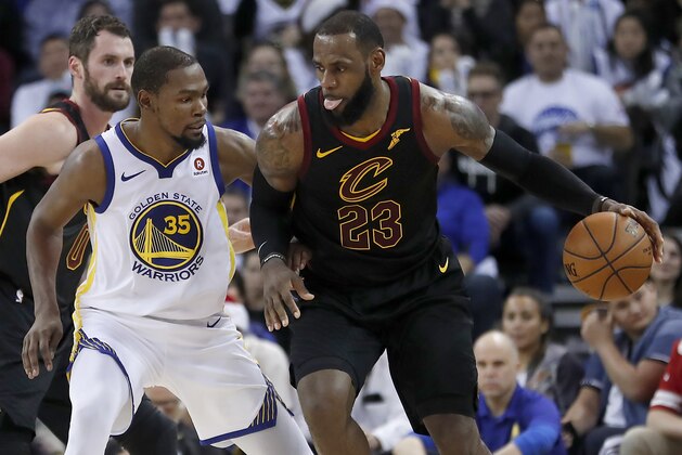 Cleveland Cavaliers forward LeBron James (23) moves the ball around Golden State Warriors forward Kevin Durant (35) during the second half of an NBA basketball game in Oakland, Calif., Monday, Dec. 25, 2017. The Warriors won 99-92. (AP Photo/Tony Avelar)