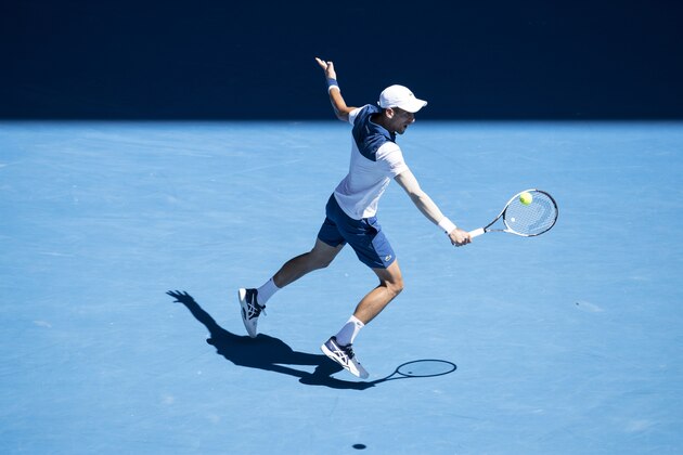 MELBOURNE, AUSTRALIA - JANUARY 18:  Novak Djokovic of Serbia plays a backhand in his second round match against Gael Monfils of France on day four of the 2018 Australian Open at Melbourne Park on January 18, 2018 in Melbourne, Australia.  (Photo by XIN LI/Getty Images)
