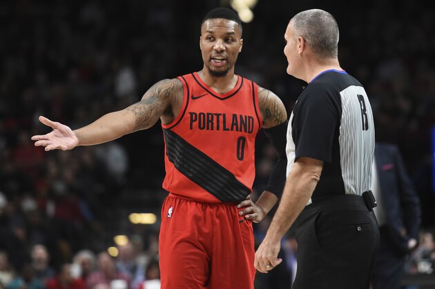 Portland Trail Blazers guard Damian Lillard has some words with referee Monty McCutchen during the first half of an NBA basketball game against the Washington Wizards in Portland, Ore., Tuesday, Dec. 5, 2017. (AP Photo/Steve Dykes)