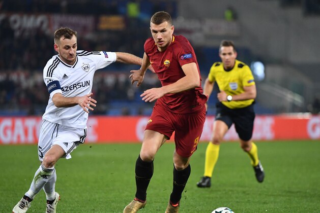 Qarabag's Azerbaijani defender Maksim Medvedev (L) vies with Roma's Bosnian striker Edin Dzeko during the UEFA Champions League Group C football match AS Roma vs FK Qarabag on December 5, 2017 at the Olympic stadium in Rome.  / AFP PHOTO / Alberto PIZZOLI        (Photo credit should read ALBERTO PIZZOLI/AFP/Getty Images)