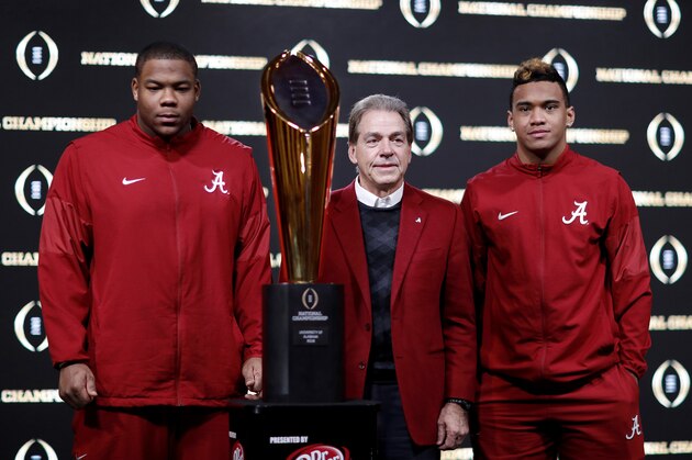 Alabama head coach Nick Saban, center, poses next to the NCAA college football championship trophy with players Da'Ron Payne, left, and Tua Tagovailoa at a press conference in Atlanta, Tuesday, Jan. 9, 2018. Alabama beat Georgia in overtime to win the NCAA college football playoff championship game. (AP Photo/David Goldman)