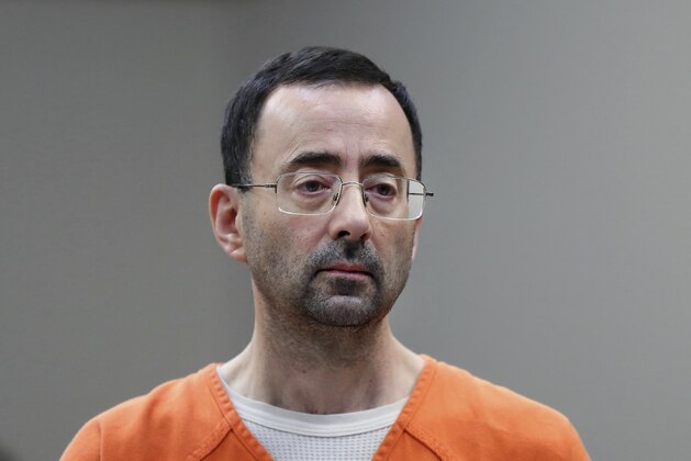 In this Nov. 22, 2017 file photo, Dr. Larry Nassar, 54, appears in court for a plea hearing in Lansing, Mich. Nasser, a sports doctor accused of molesting girls while working for USA Gymnastics and Michigan State University pleaded, guilty to multiple charges of sexual assault and will face at least 25 years in prison.(AP Photo/Paul Sancya)
