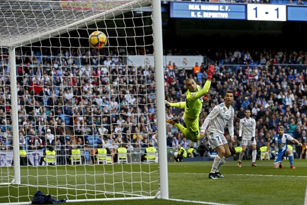 Real Madrid's Gareth Bale, background second right, scores past Deportivo Coruna's goalkeeper Ruben Martinez his team's second goal during a Spanish La Liga soccer match between Real Madrid and Deportivo Coruna at the Santiago Bernabeu stadium in Madrid, Sunday, Jan. 21, 2018. (AP Photo/Francisco Seco)
