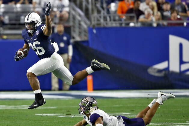 Penn State running back Saquon Barkley (26) leaps over Washington defensive back Myles Bryant (5) during the second half of the Fiesta Bowl NCAA college football game Saturday, Dec. 30, 2017, in Glendale, Ariz. (AP Photo/Ross D. Franklin)