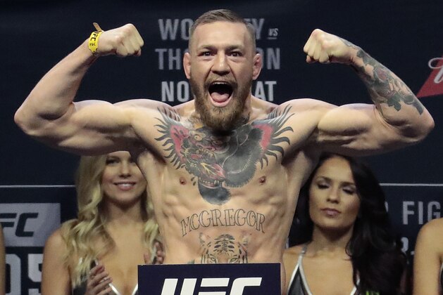 FILE - In this Nov. 11, 2016, file photo, Conor McGregor stands on a scale during the weigh-in event for his fight against Eddie Alvarez in UFC 205 mixed martial arts at Madison Square Garden in New York.  Floyd Mayweather Jr. says facing UFC star McGregor in a boxing ring