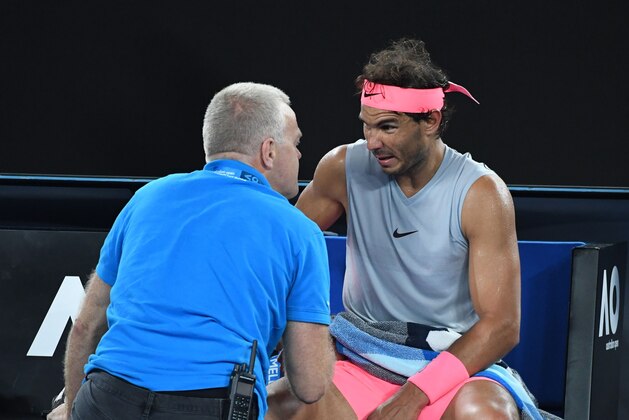 Spain's Rafael Nadal receives medical attention during their men's singles quarter-finals match against Croatia's Marin Cilic on day nine of the Australian Open tennis tournament in Melbourne on January 23, 2018. / AFP PHOTO / WILLIAM WEST / -- IMAGE RESTRICTED TO EDITORIAL USE - STRICTLY NO COMMERCIAL USE --        (Photo credit should read WILLIAM WEST/AFP/Getty Images)