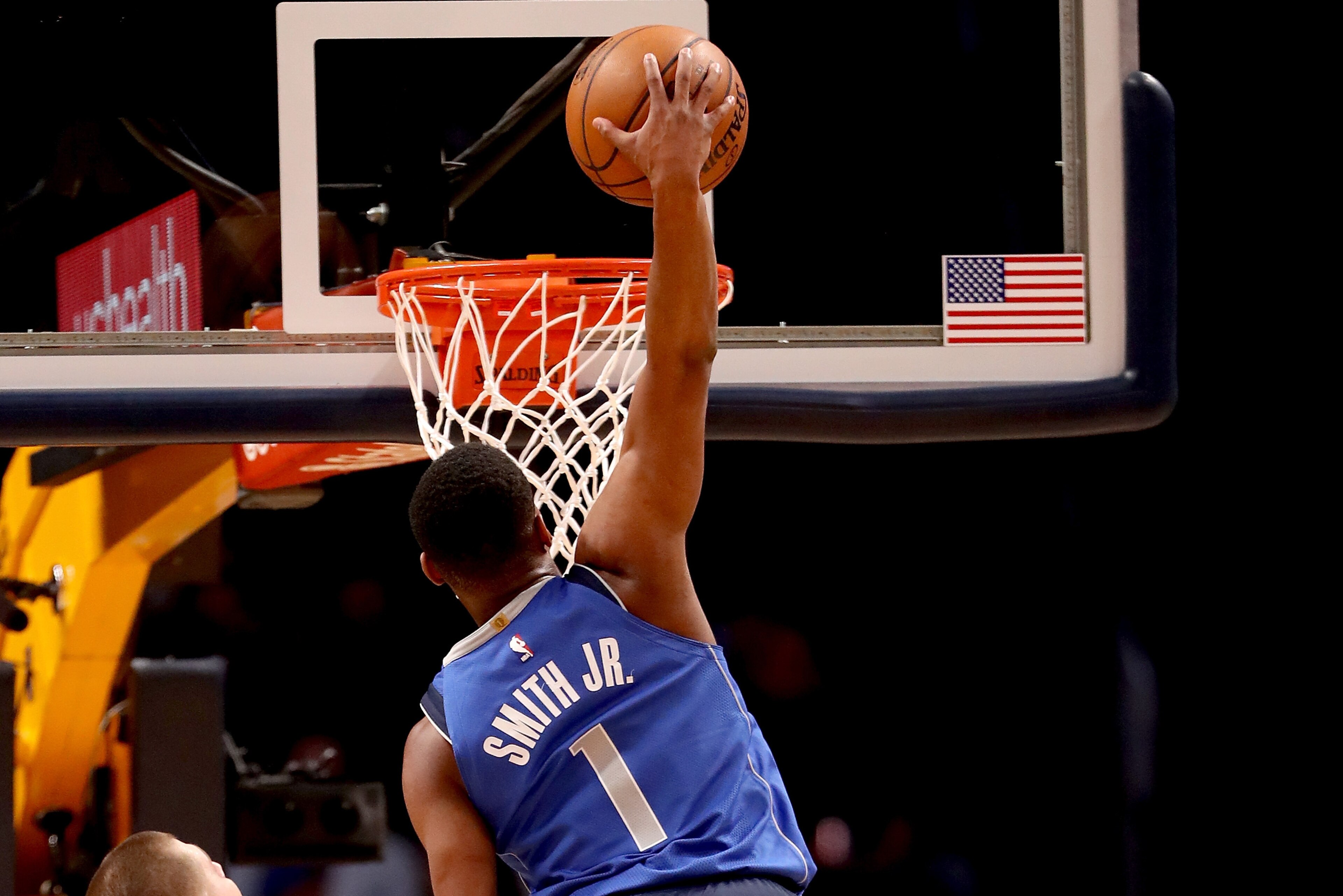 DENVER, CO - JANUARY 16:  Dennis Smith Jr. #1 of the Dallas Mavaricks dunks against Nikola Jokic #15 and Gary Harris #14 of the Denver Nuggets at the Pepsi Center on January 16, 2018 in Denver, Colorado. NOTE TO USER: User expressly acknowledges and agrees that, by downloading and or using this photograph, User is consenting to the terms and conditions of the Getty Images License Agreement.  (Photo by Matthew Stockman/Getty Images)