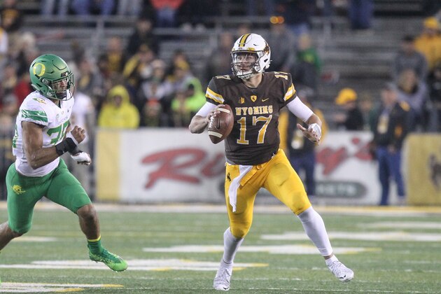 Wyoming quarterback Josh Allen (17) avoids a tackle from Oregon inside linebacker Troy Dey (35) during the second half of an NCAA college football game in Laramie, Wyo., Saturday, Sept.16, 2017. (AP Photo/Shannon Broderick)