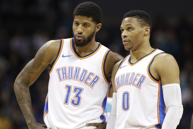 Oklahoma City Thunder's Paul George (13) talks with Russell Westbrook (0) during the first half of an NBA basketball game against the Charlotte Hornets in Charlotte, N.C., Saturday, Jan. 13, 2018. (AP Photo/Chuck Burton)