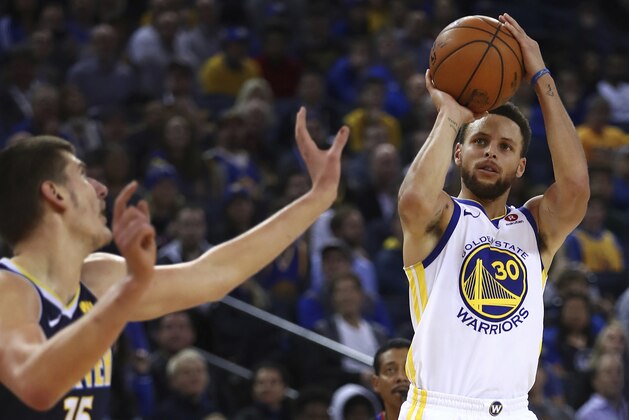 Golden State Warriors' Stephen Curry, right, shoots against Denver Nuggets' Nikola Jokic (15) during the second half of an NBA basketball game Monday, Jan. 8, 2018, in Oakland, Calif. Golden State won, 124-114. (AP Photo/Ben Margot)