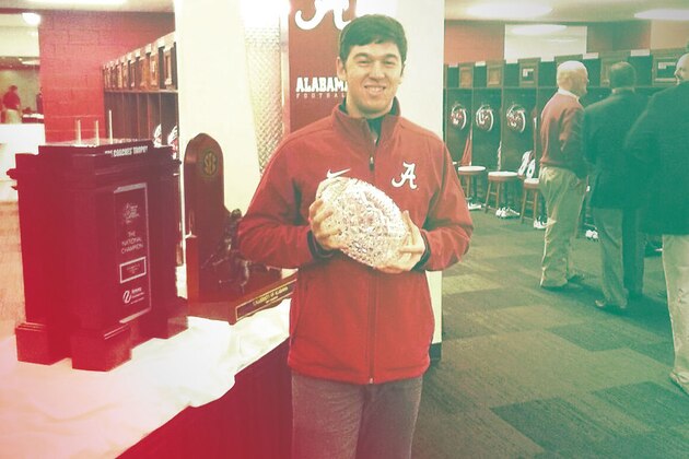 Charlie Weis Jr. poses with the national championship trophy in January 2016, when he was a graduate assistant at Alabama.
