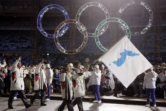 FILE - In this Feb. 10, 2006, file photo, Korea flag-bearer's Bora Lee and Jong-In Lee, carrying a unification flag lead their teams into the stadium during the 2006 Winter Olympics opening ceremony in Turin, Italy. North Korea plans to send a spotlight-stealing delegation to next month’s Winter Olympics in the South Korean county of Pyeongchang. (AP Photo/Amy Sancetta, File)