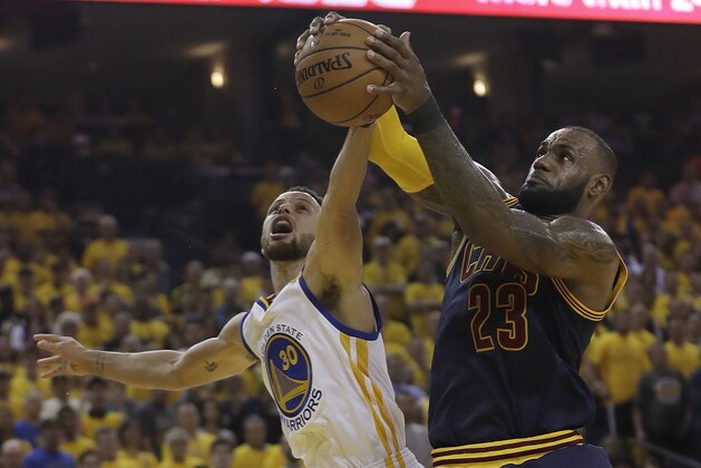 Cleveland Cavaliers forward LeBron James (23) grabs a rebound against Golden State Warriors guard Stephen Curry (30) during the first half of Game 1 of basketball's NBA Finals in Oakland, Calif., Thursday, June 1, 2017. (AP Photo/Marcio Jose Sanchez)