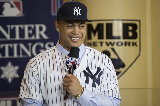 FILE - In this Dec. 11, 2017, file photo, New Yankees player Giancarlo Stanton answers questions during a press conference at the Major League Baseball winter meetings in Orlando, Fla. Derek Jeter, The Player, glided through two decades in the Big Apple. His charisma made it all look so effortless, a beloved figure who could seemingly do no wrong, even in the media cauldron that is New York City. Which makes Derek Jeter, The Baseball Executive, all the more baffling. Frankly, he had no real options beyond dumping MVP slugger Giancarlo Stanton and the worst contract in sports history on his former team.  (AP Photo/Willie J. Allen Jr., File)