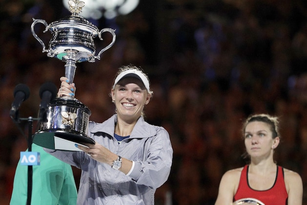 Denmark's Caroline Wozniacki, left, holds her trophy after defeating Romania's Simona Halep, right, in the women's singles final at the Australian Open tennis championships in Melbourne, Australia, Saturday, Jan. 27, 2018. (AP Photo/Dita Alangkara)