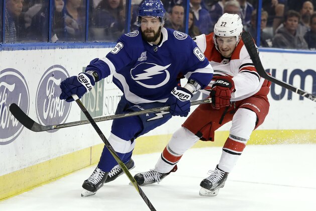 Tampa Bay Lightning right wing Nikita Kucherov (86), of Russia, pushes the puck away from Carolina Hurricanes defenseman Brett Pesce (22) during the second period of an NHL hockey game Tuesday, Jan. 9, 2018, in Tampa, Fla. (AP Photo/Chris O'Meara)