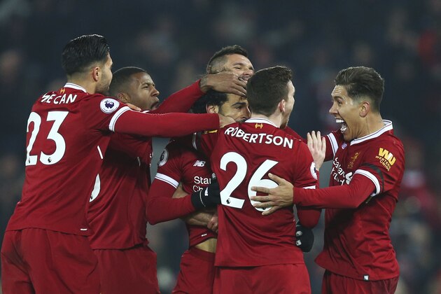 Liverpool players celebrate with Mohamed Salah, center, after he scored his side's fourth goal during the English Premier League soccer match between Liverpool and Manchester City at Anfield Stadium, in Liverpool, England, Sunday Jan. 14, 2018. Salah scored the wining goal. (AP Photo/Dave Thompson)